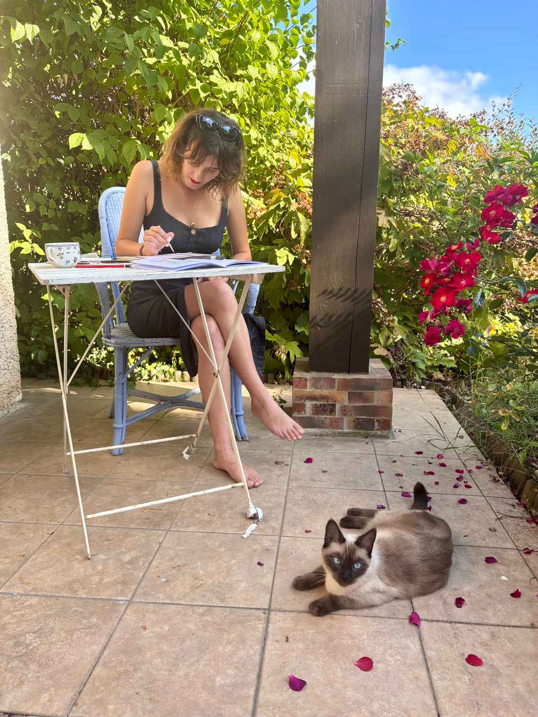 Fanny peint à la table du jardin avec son chat